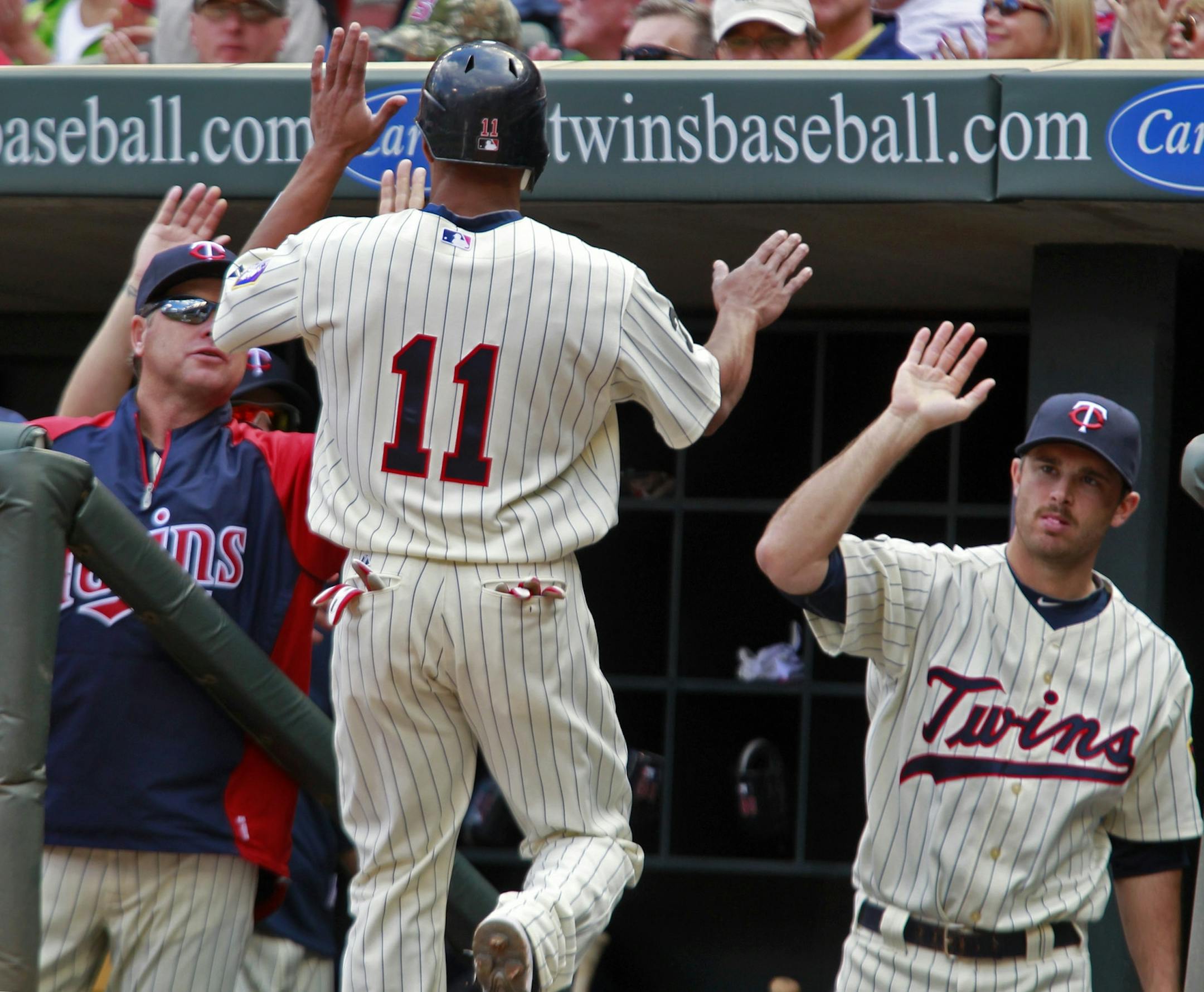 Twins runner Ben Revere is congratulated by teammates in the dugout after he scored a run in the first inning.