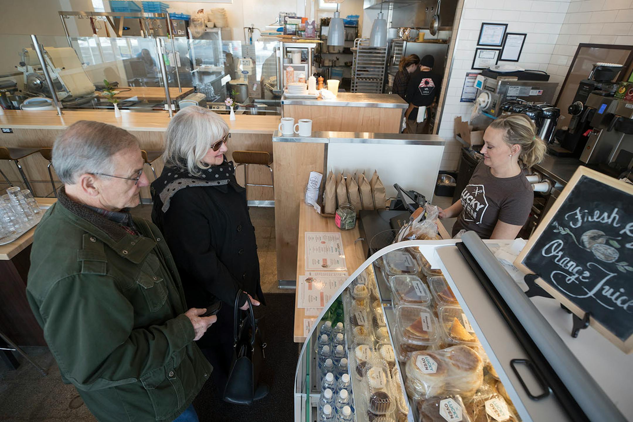 Jennifer Edge right, an employee at the Lucky Oven Bakery to a breakfast order from Wally Roers and his wife Christy Roers Feb 9, 2018 in Minneapolis, MN.