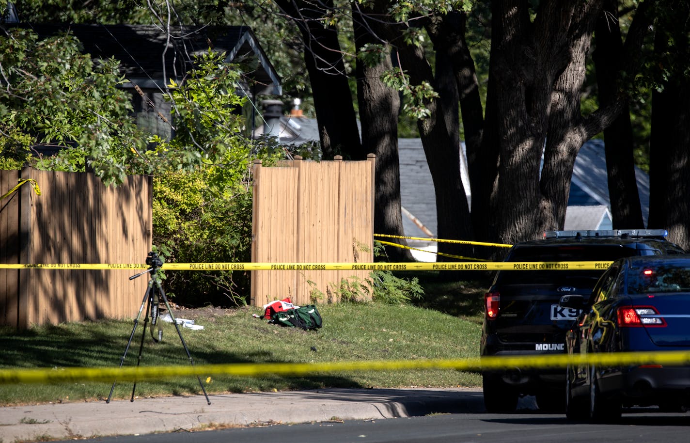 Police and BCA vehicles near a broken piece of fencing at a home at the intersection of Pinewood Ct. and CO RD H2 in Mounds View.