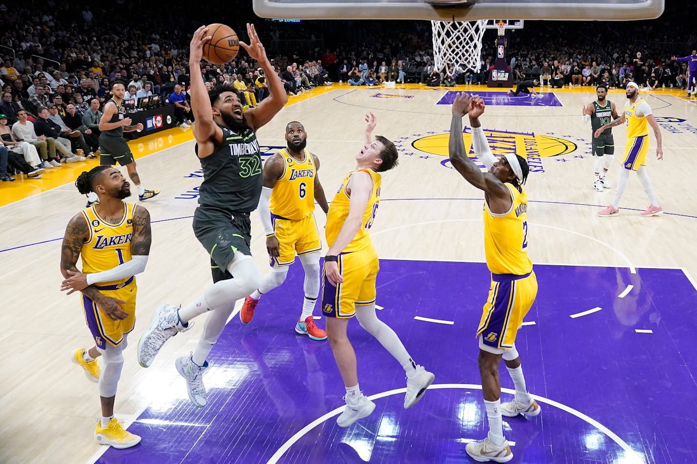 Minnesota Timberwolves forward Karl-Anthony Towns (32) shoots from between Los Angeles Lakers guard D'Angelo Russell (1), forward LeBron James (6), guard Austin Reaves (15) and forward Jarred Vanderbilt (2) during the first half of an NBA basketball play-in tournament game Tuesday, April 11, 2023, in Los Angeles. (AP Photo/Marcio Jose Sanchez)