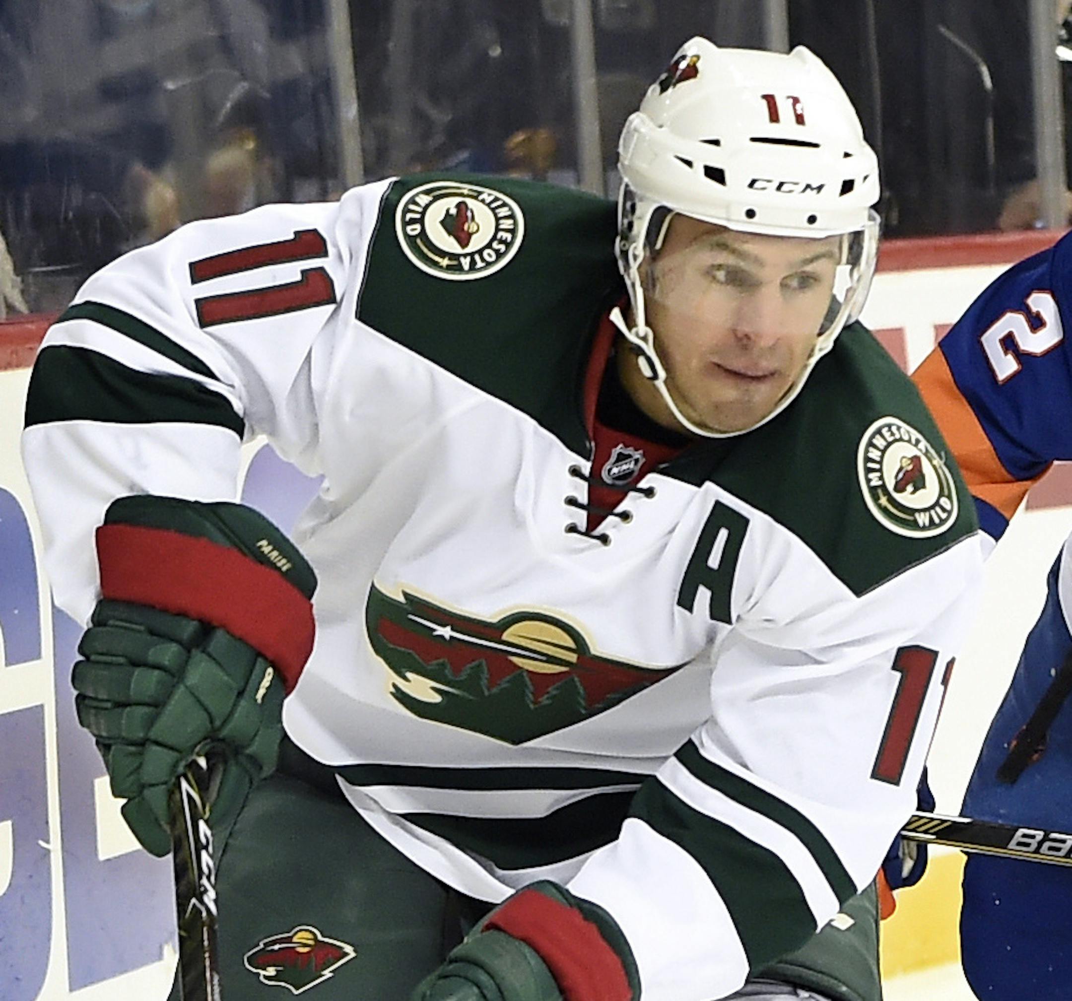 Minnesota Wild left wing Zach Parise (11) drives the puck around the boards away from New York Islanders defenseman Nick Leddy (2) in the third period of an NHL hockey game in New York, Sunday, Oct. 23, 2016. (AP Photo/Kathy Kmonicek)