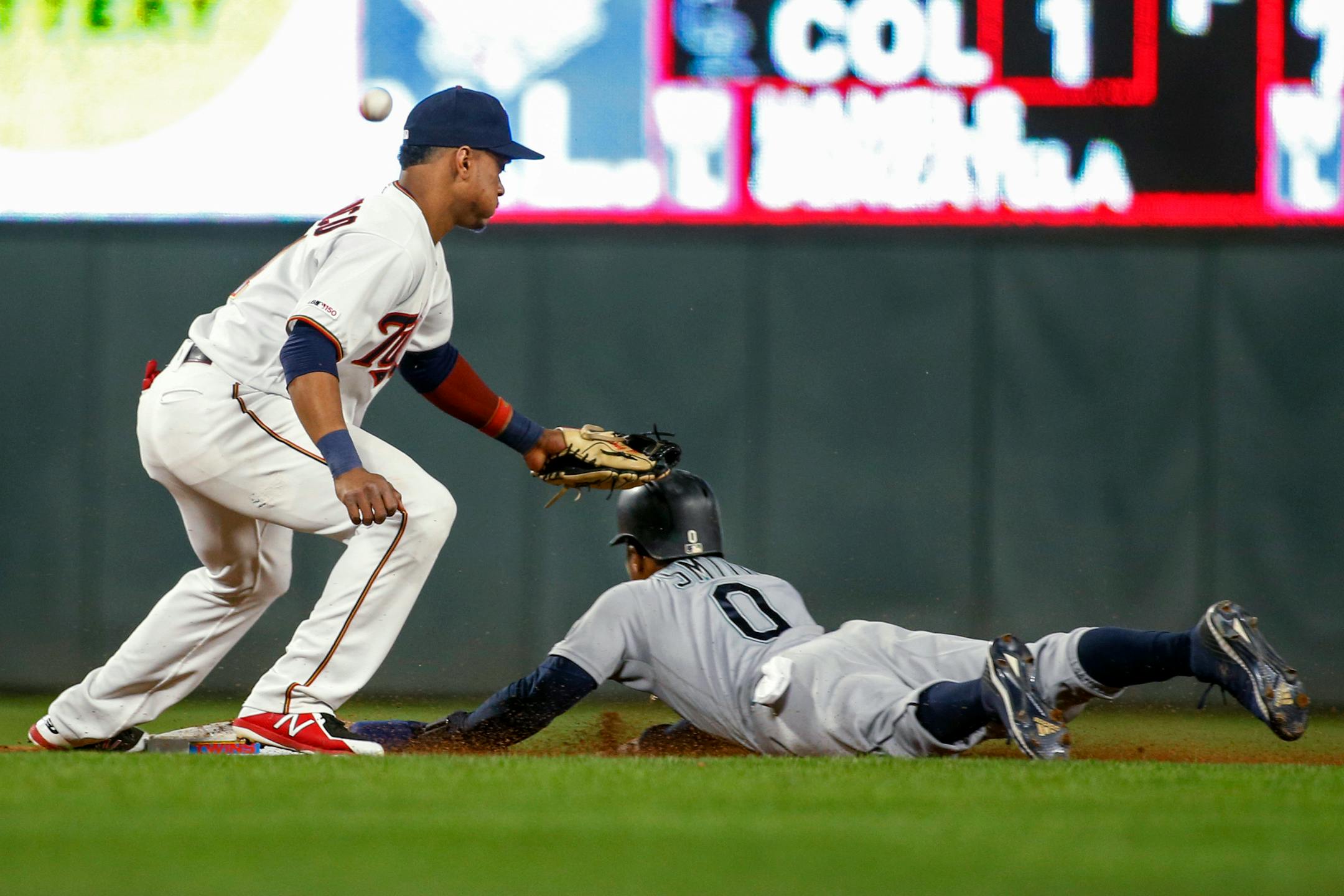Seattle Mariners' Mallex Smith steals second base as Minnesota Twins shortstop Jorge Polanco misses the ball on a throwing error by catcher Mitch Garver during the eighth inning