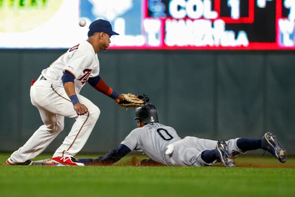 Seattle Mariners' Mallex Smith steals second base as Minnesota Twins shortstop Jorge Polanco misses the ball on a throwing error by catcher Mitch Garv