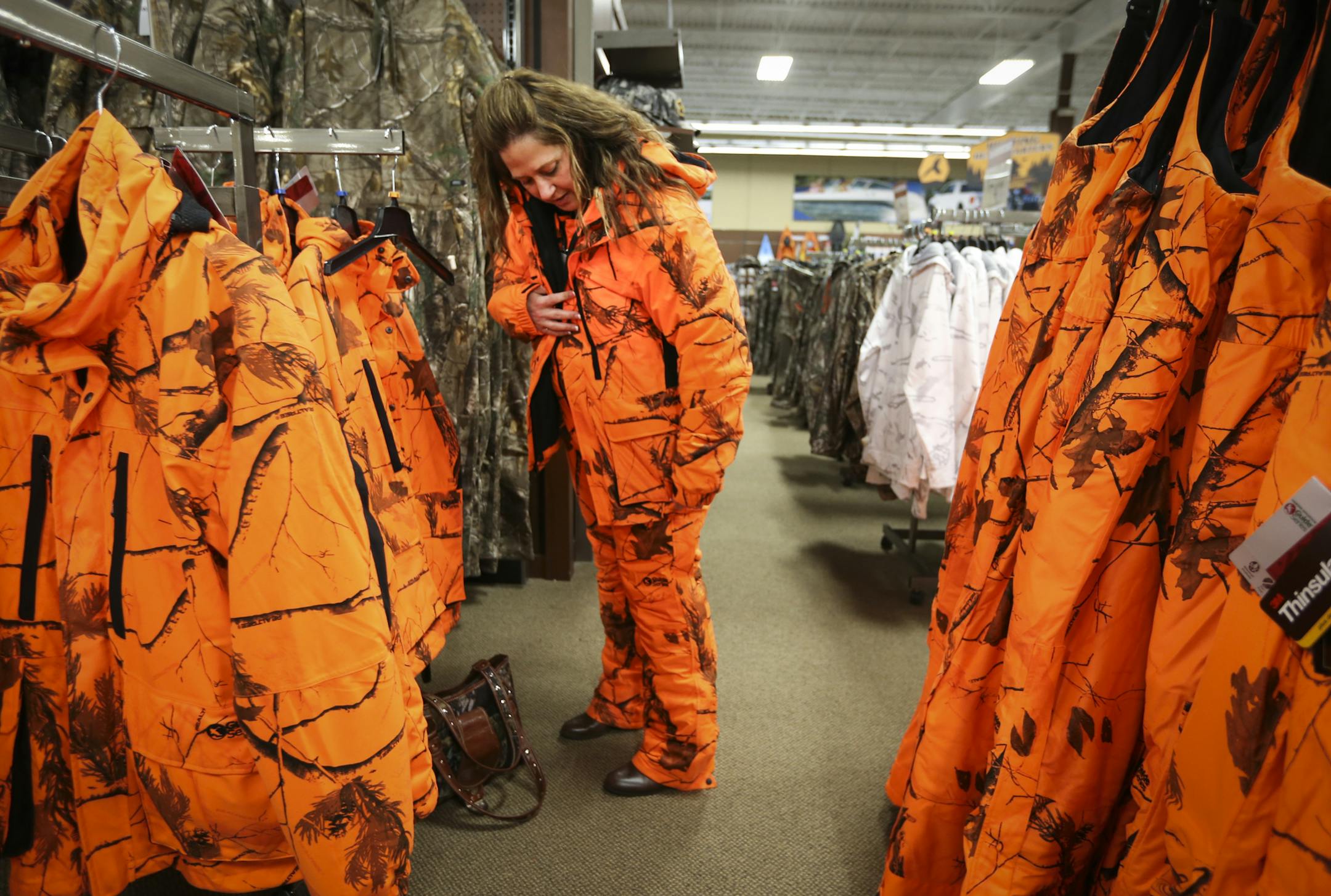 Kari Rhodes, of New Brighton, tried on a blaze camouflage hunting jacket and pants at Gander Mountain in Blaine, Minn. on Friday, October 31, 2014. ] RENEE JONES SCHNEIDER • reneejones@startribune.com