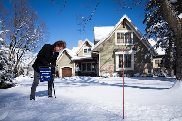 Real estate agent Jeffrey Dewing secured a sign outside a house he’s selling in Wayzata earlier this month.