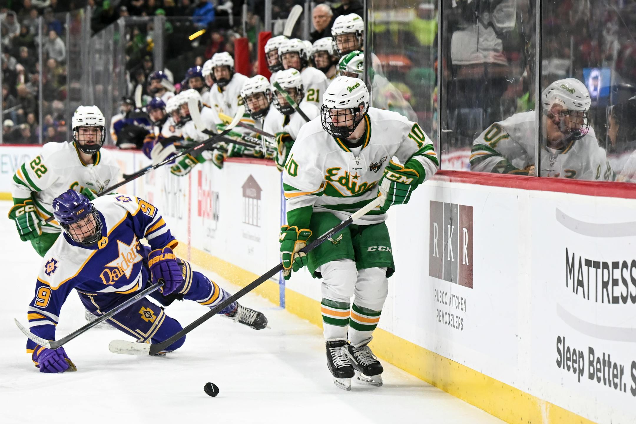 Edina forward John Halverson (10) controls the puck as Cretin-Derham Hall forward Easton Swift (9) falls to the ice during the second period.