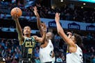 Charlotte Hornets guard Theo Maledon, left, shoots around Minnesota Timberwolves guard Jaylen Nowell, center, and center Karl-Anthony Towns during the