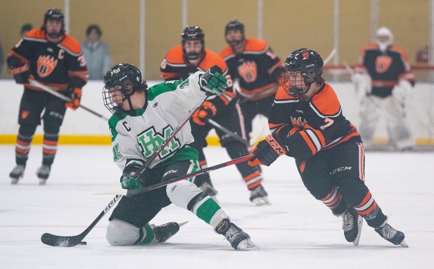 Hill-Murray defender Leo Gruba (11) controls the puck on one knee in the first period of the Class 2A Section 4 Championship Friday, March 4, 2022 at Aldrich Ice Arena in Maplewood, Minn. ]