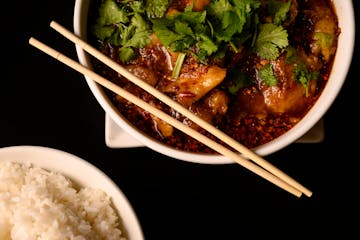 The House Spicy Fish stews fish fillets in chili broth served with Chinese cabbage and bean sprouts.