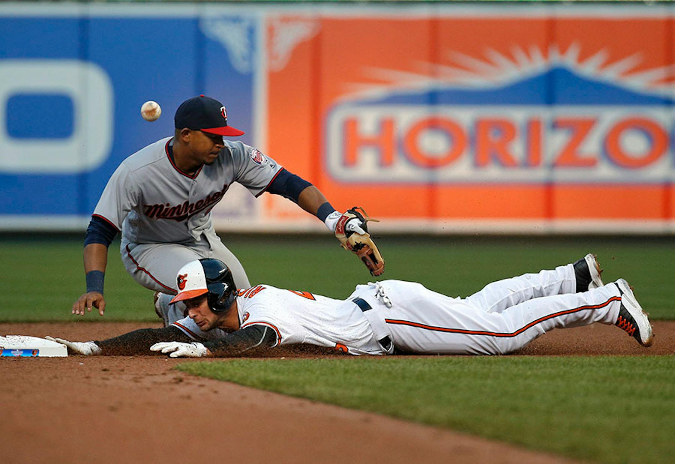 Baltimore Orioles' Joey Rickard beats a throw to Minnesota Twins shortstop Eduardo Escobar (5) for a double in the fifth inning of an opening day baseball game in Baltimore, Monday, April 4, 2016. (AP Photo/Patrick Semansky)