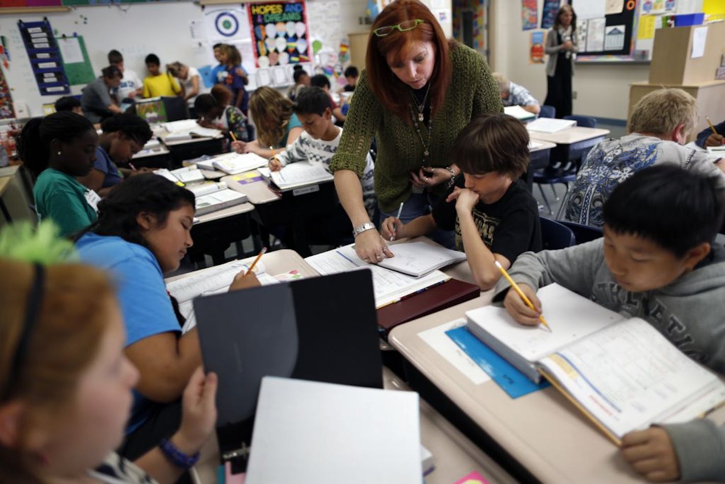 At Woodland Elementary, teacher's aide Lisa McQuerter helped sixth-grader Lukas Robinson with his math. There are 33 students in Lukas' class.