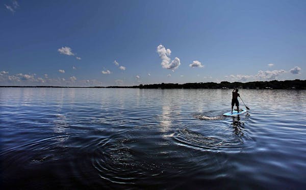A man used a paddle board to cross an unusually serene Lake Minnetonka.