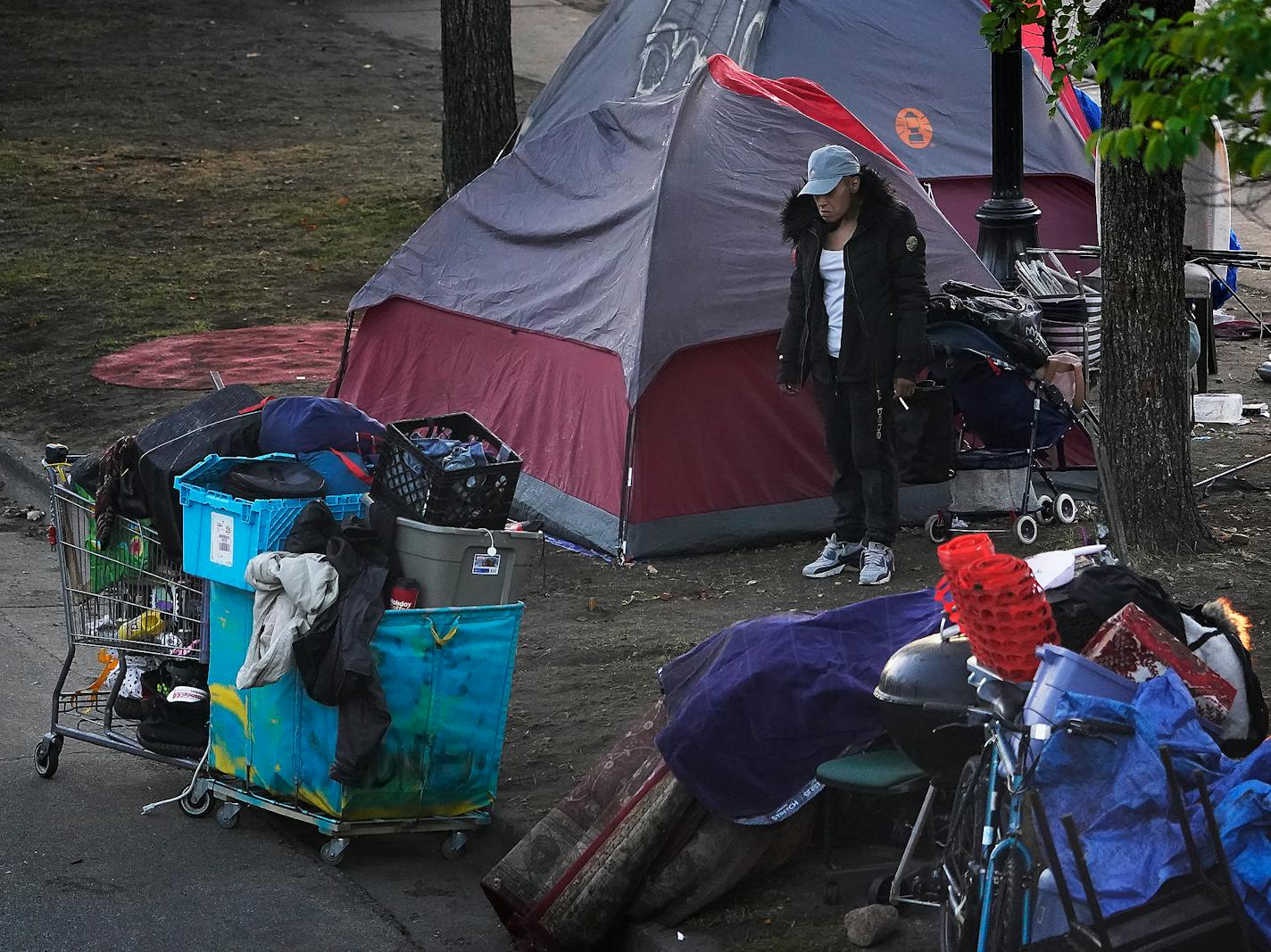 City of Minneapolis workers and officials cleared out a a homeless encampment in a median near the intersection of Franklin and Cedar avenues Tuesday in Minneapolis. Here, a former resident looked at her belongings before leaving. ]