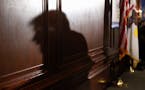 The shadow of Republican presidential candidate Donald Trump is cast against the wall as he speaks to members of the City Club of Chicago, Monday, Jun
