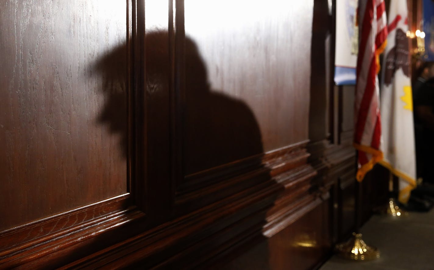 The shadow of Republican presidential candidate Donald Trump is cast against the wall as he speaks to members of the City Club of Chicago, Monday, June 29, 2015, in Chicago. (AP Photo/Charles Rex Arbogast)