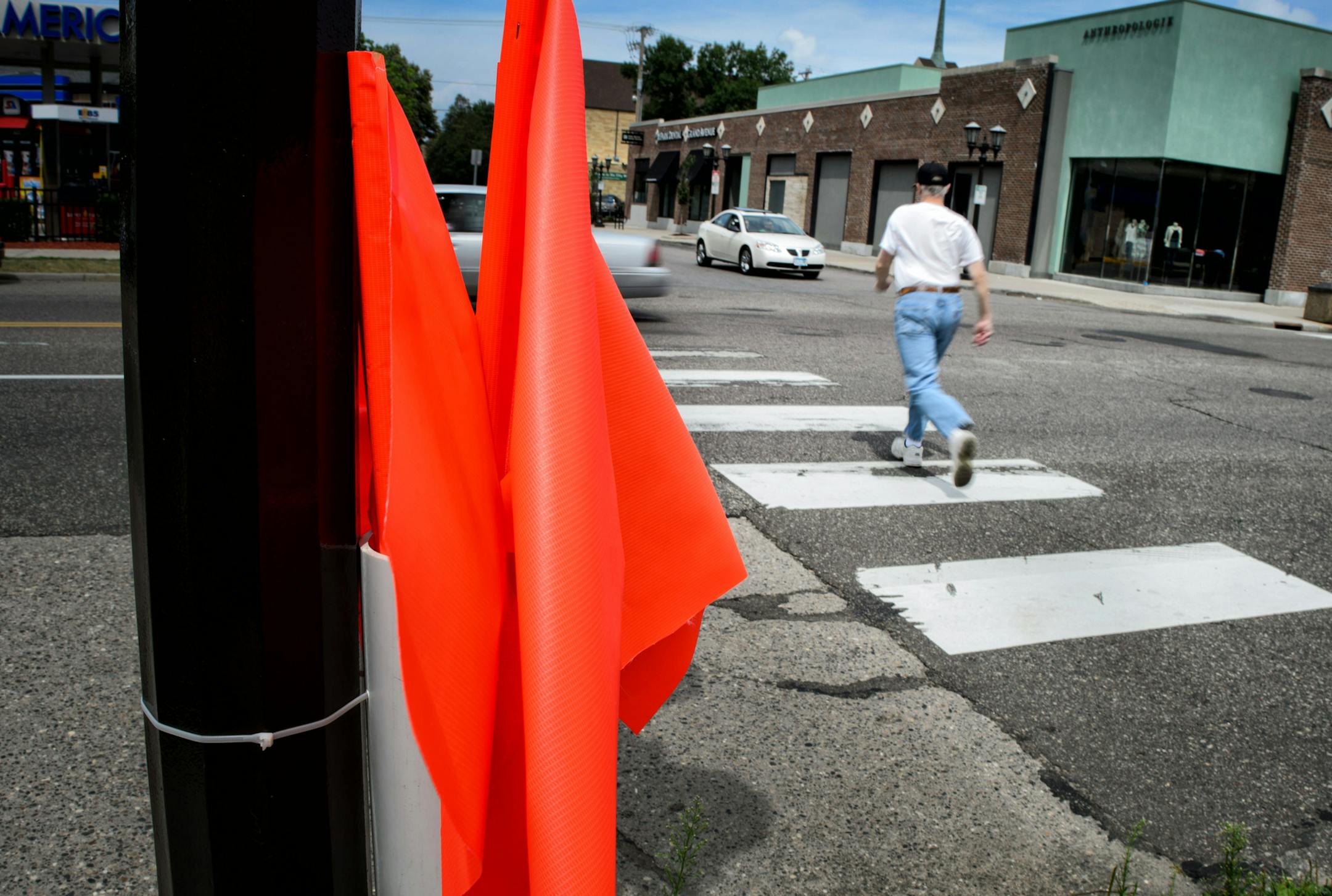Despite orange flags at the west side of the Grand Avenue and Milton St intersection in St. Paul, pedestrians ignored them and depended on the alertness of motorists as they crossed Grand. ] Tuesday, August 5, 2014. GLEN STUBBE * gstubbe@startribune.com