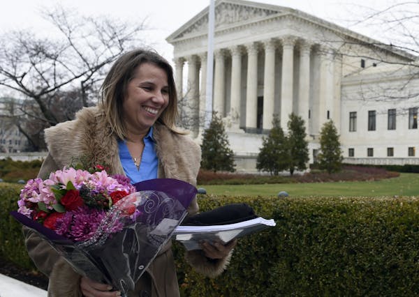 Peggy Young, a Virginia woman who lost her UPS job because she became pregnant, carries a bouquet of flowers as she leaves the Supreme Court in Washin