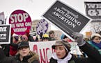 Anti-abortion activists and supporters of legal abortion stand in front of the Supreme Court in Washington, Friday, Jan. 25, 2013, on the 40th anniver