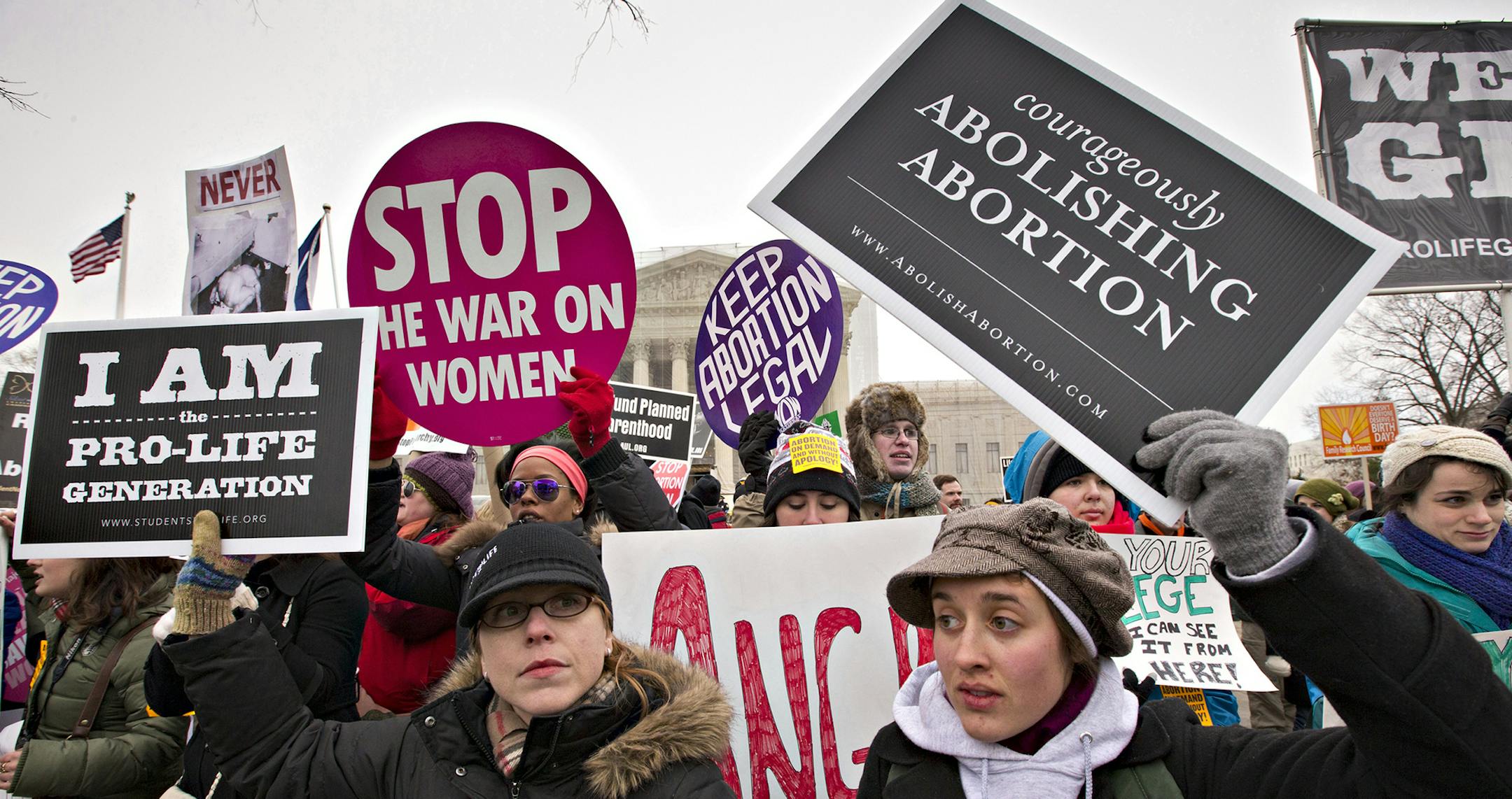 Anti-abortion activists and supporters of legal abortion stand in front of the Supreme Court in Washington, Friday, Jan. 25, 2013, on the 40th anniversary of the Roe v. Wade decision. Thousands of anti-abortion demonstrators marched through Washington to the steps of the U.S. Supreme Court to protest the landmark decision that legalized abortion. (AP Photo/J. Scott Applewhite) ORG XMIT: DCSA110 ORG XMIT: MIN1401141236411965