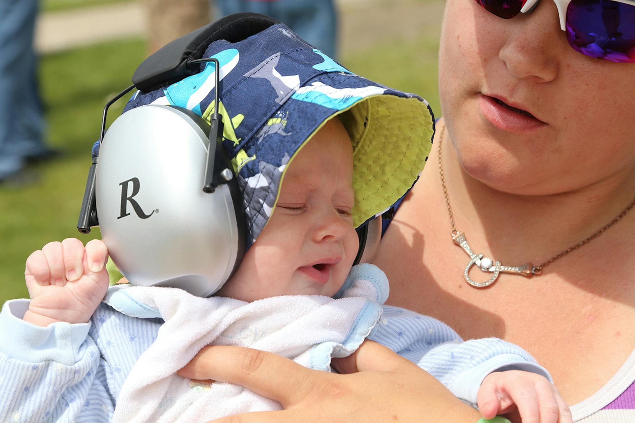 Elizabeth Bain of Stewartville, aunt of R.J. Peterson, ensures the little guy's ears are protected Thursday at the state High School Trapshooting Championship in Alexandria.