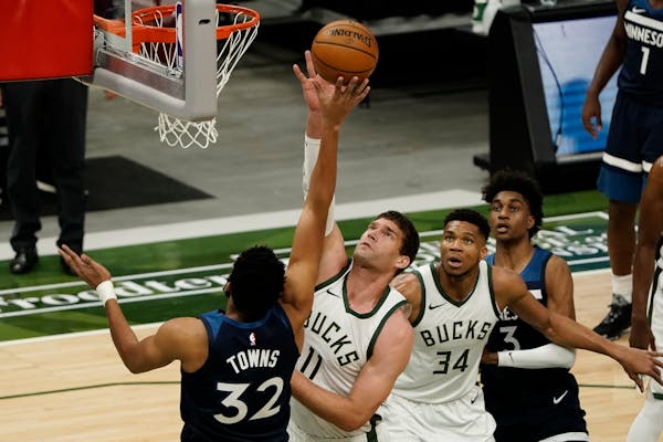 Milwaukee's Brook Lopez blocks a shot by Timberwolves center Karl-Anthony Towns during the first half Tuesday.