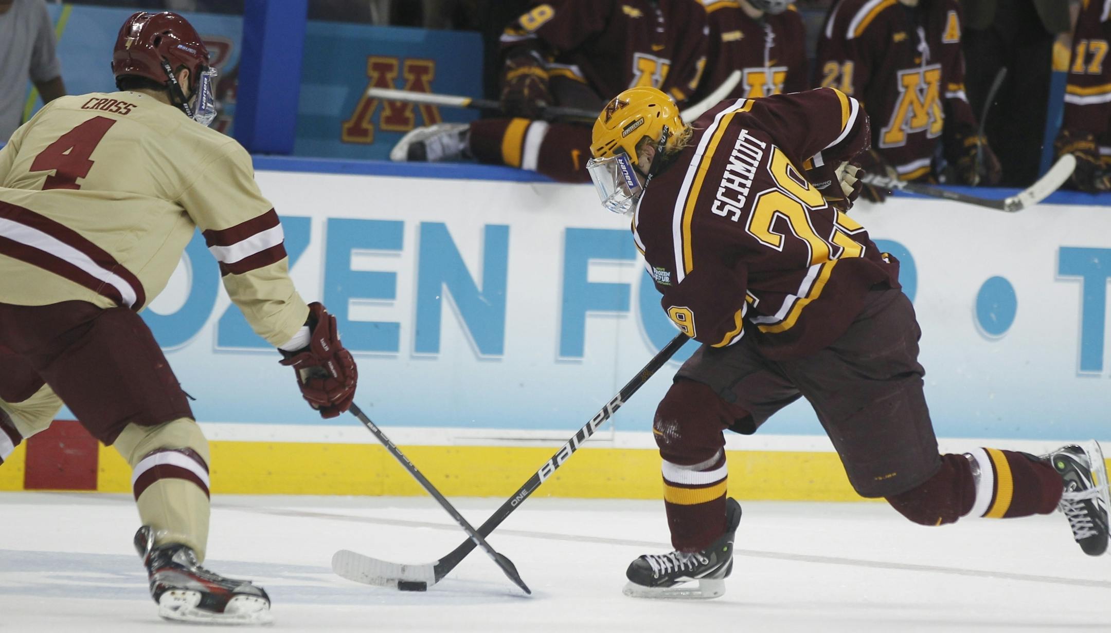 Boston College's Tommy Cross(4) tries to take the puck from Minnesota's Nate Schmidt (29).