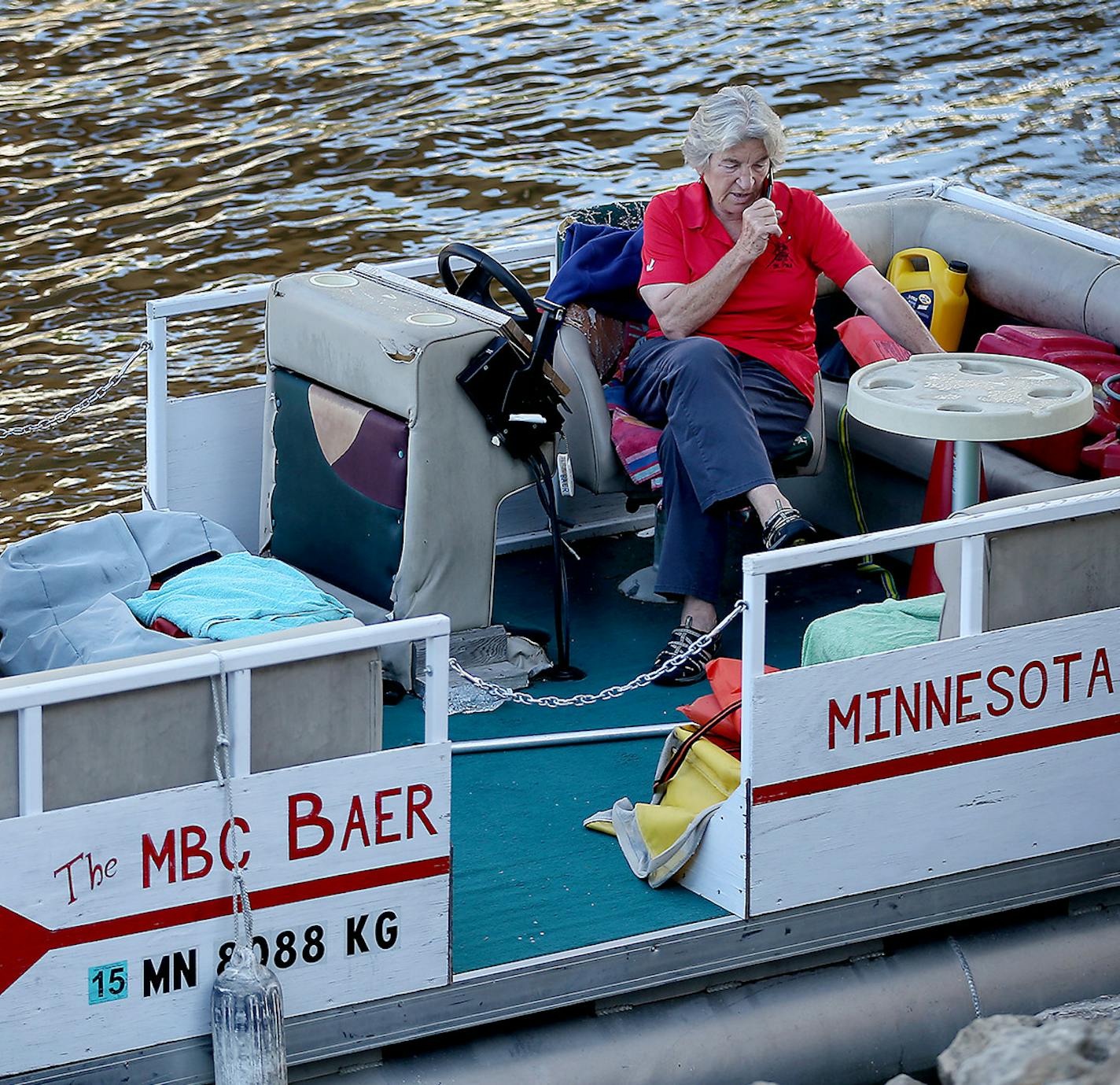 Minnesota Boat Club coach Miriam Baer, 72, took a phone call on her pontoon as she waited for a couple of teens who wanted to continue to practice, Wednesday, August 12, 2015 in St. Paul, MN. ] (ELIZABETH FLORES/STAR TRIBUNE) ELIZABETH FLORES &#x2022; eflores@startribune.com