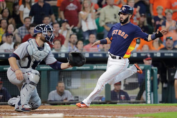 Houston Astros' Marwin Gonzalez, right, scores against the Twins during a 2017 game.