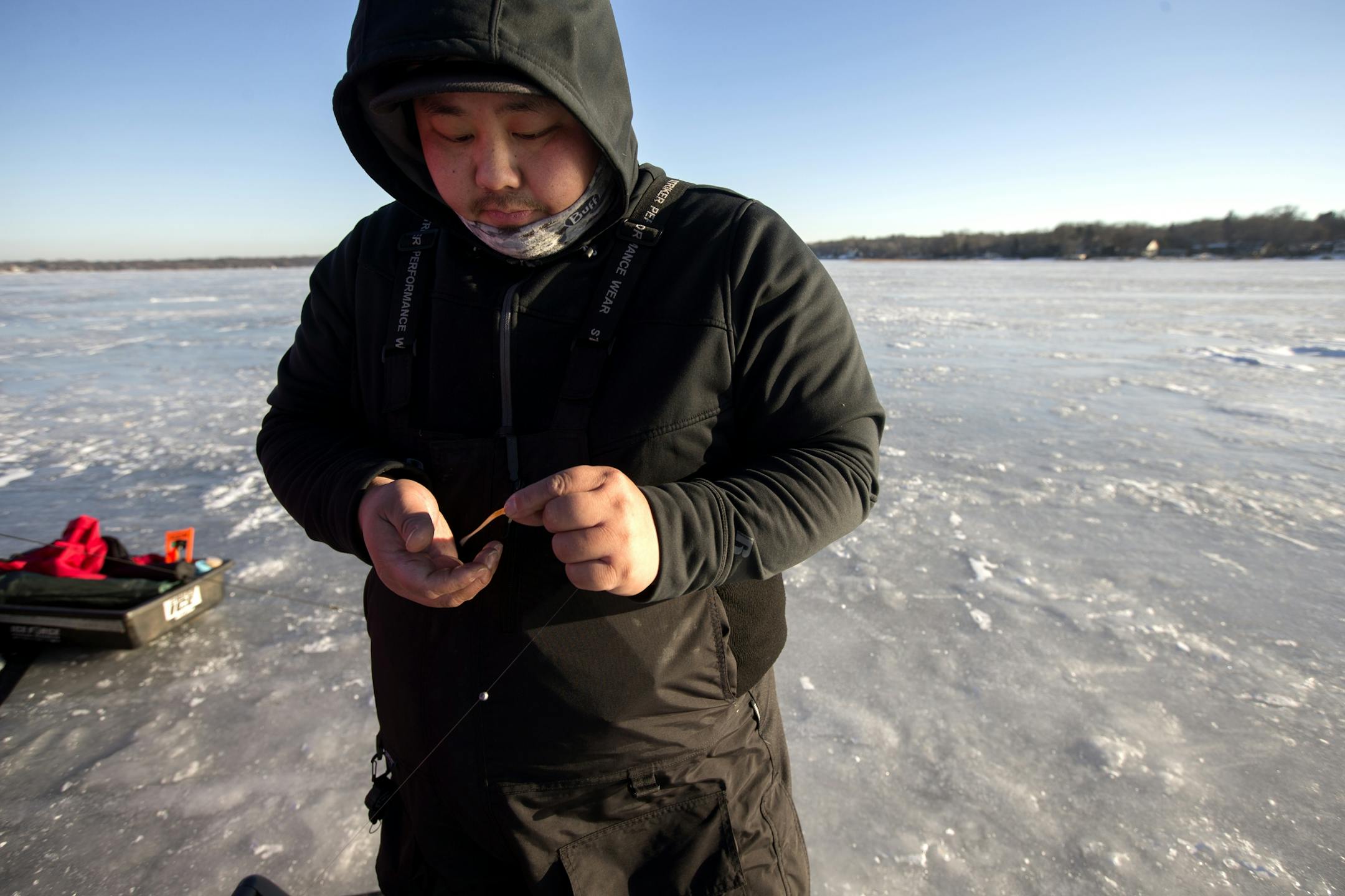 Thomas Lee tied his jig on while ice fishing on White Bear Lake on Wednesday, Dec. 28. A midweek cold snap should keep ice fishing temps ideal.