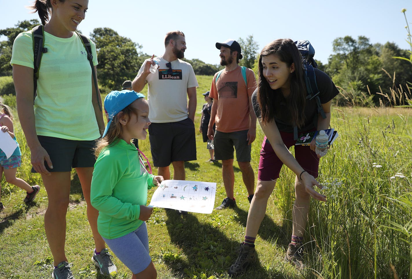 Guide Kelsey Wotzka, right, showed a flower to Mathilde Keller-Lewis, 5, who was visiting from Texas, during a nature hike sponsored by L.L. Bean Saturday at the Richardson Nature Center in Bloomington. ] ANTHONY SOUFFLE &#xef; anthony.souffle@startribune.com L.L. Bean sponsors free outdoors activities for kids and families including a hike Saturday, July 8, 2017 at the Richardson Nature Center in Bloomington, Minn.