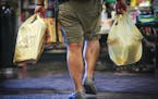 A man carried plastic bags of groceries out of Kowalski's in Uptown in Minneapolis, Minn., on Thursday, July 23, 2015. ] RENEE JONES SCHNEIDER &#x2022