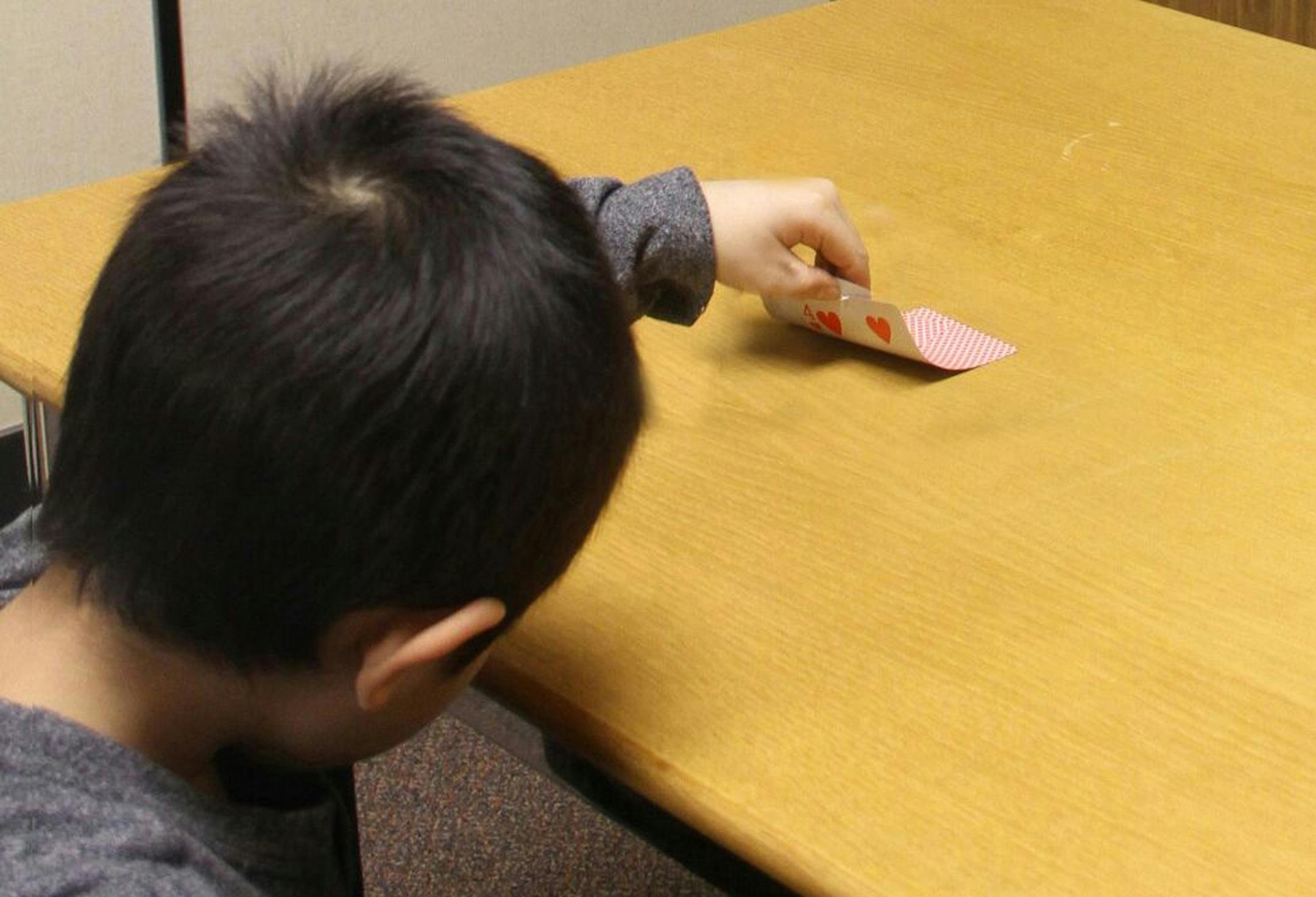 In this Jan. 27, 2016 photo provided by the University of Toronto, a child peeks at a hidden card when an adult leaves the room and later lies about not peeking in research about how young children start to lie by Kang Lee at the University of Toronto in Toronto. Scientists say we all lie, and this year, politicians are bending the truth big time, with real consequences. By studying how and why we deceive, the experts say they can help us better understand the 2016 election season. (Paul Zheng/U