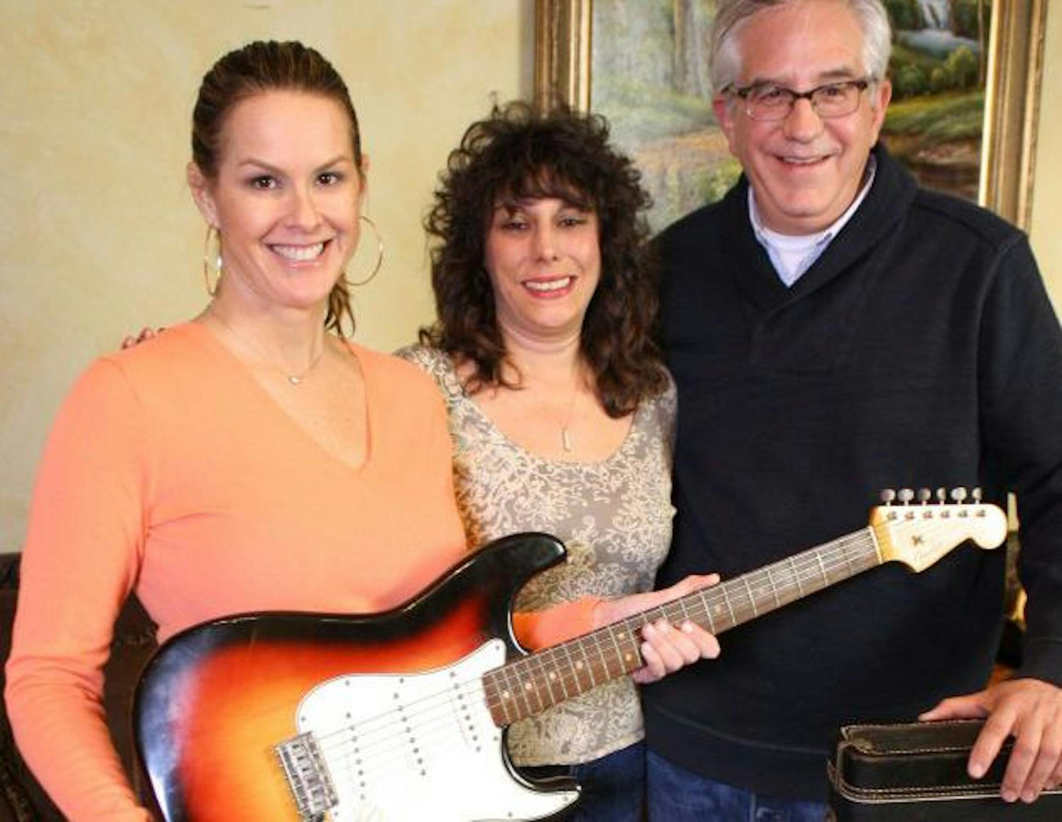 This undated image released by PBS shows, from left, Elyse Luray, contributor Dawn Peterson and Wes Cowan, from "History Detectives" with Bob Dylan's guitar. The electric guitar that Bob Dylan plugged in at the Newport Folk Festival in 1965 may be the most historic instrument in rock music, and it has sat mostly unnoticed in a New Jersey attic for most of the 47 years since. Dylan left it behind in an airplane and it was taken home by the pilot. The late pilot's daughter recently took it to PBS'