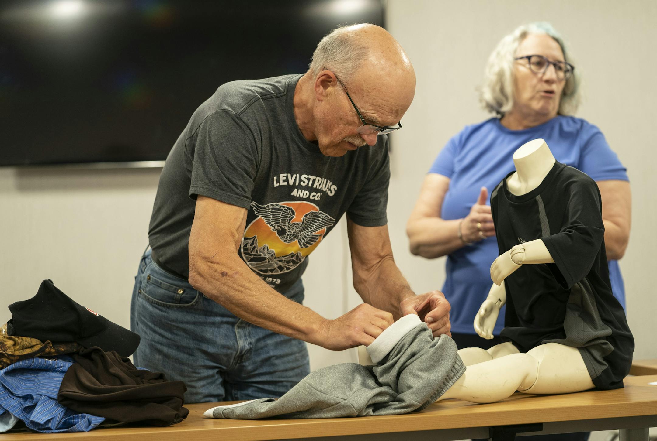 Larry Lutz practiced putting on someone's pants using a mannequin as instructor Kim Stender (behind him) led a personal cares training session for Right at Home employees in Bloomington, Minn., on Thursday, May 23, 2019. ] RENEE JONES SCHNEIDER ¥ renee.jones@startribune.com