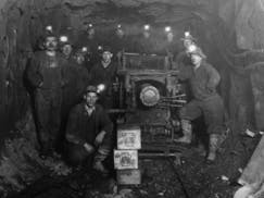 A group of miners stood next to an ore car on the Iron Range around the turn of the century. The precise location of the photo is not known.