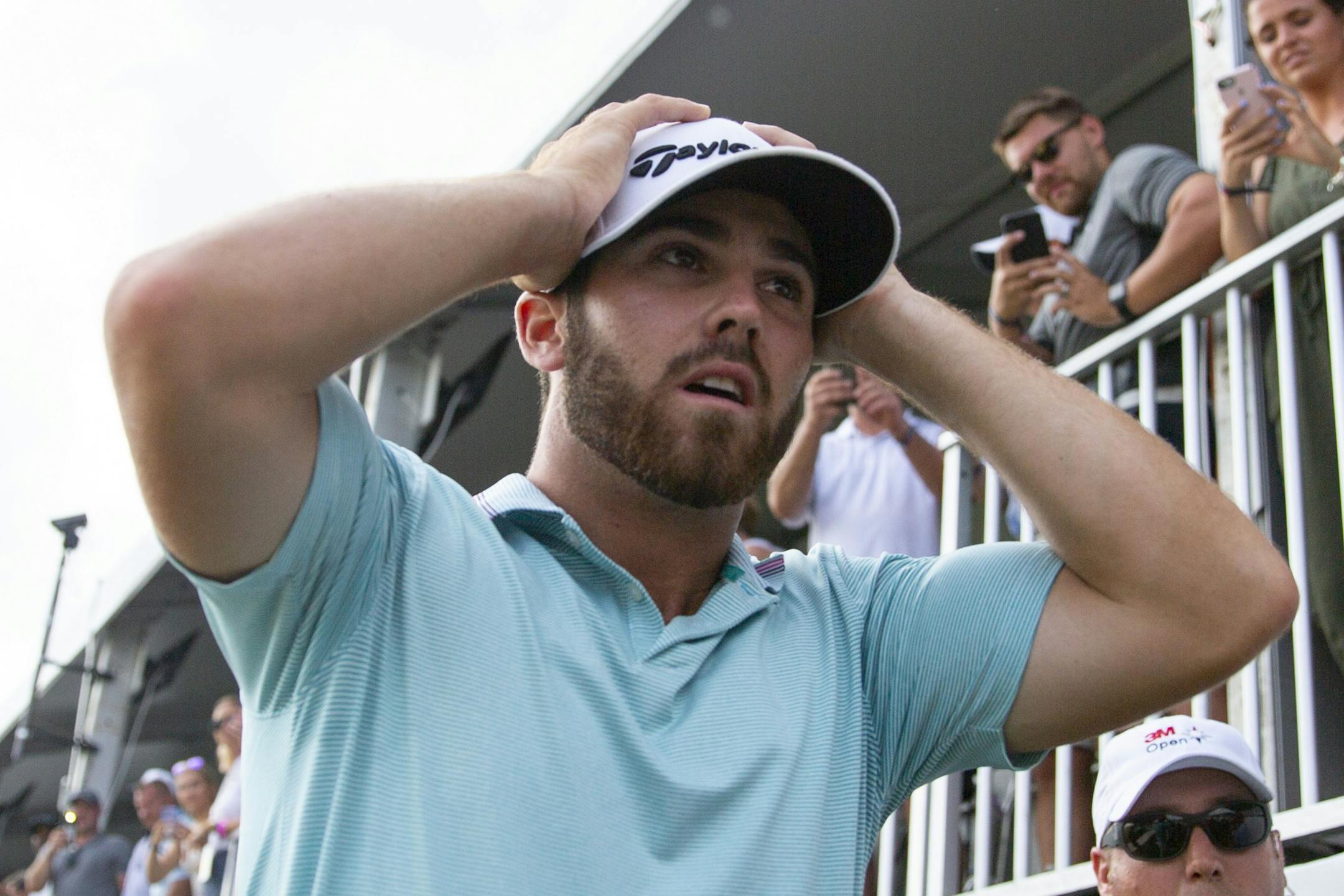 Matthew Wolff holds his head and walks off the course in disbelief after hitting an eagle to win the 3M Open.