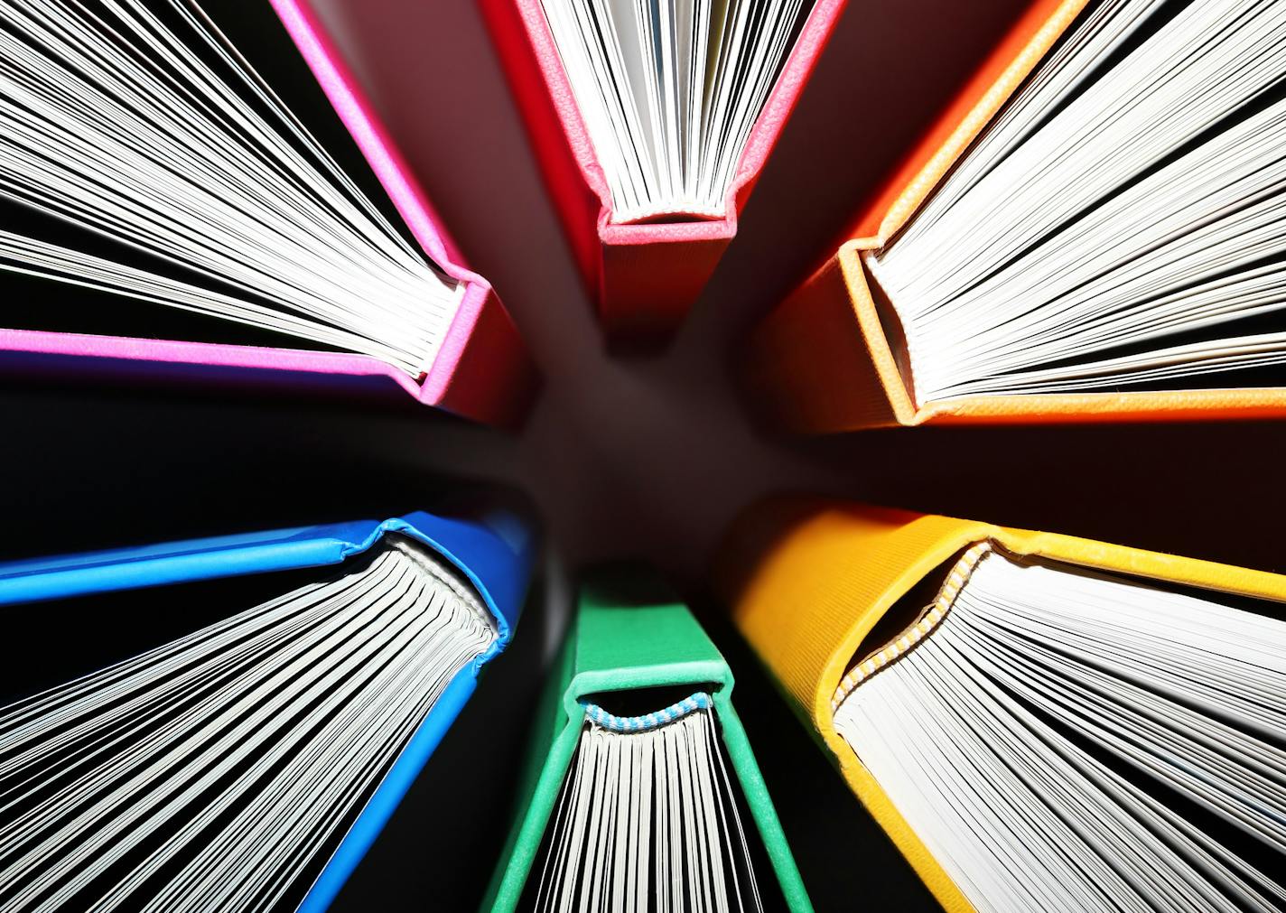 Fanned out colorful books forming an abstract pattern of explosion.