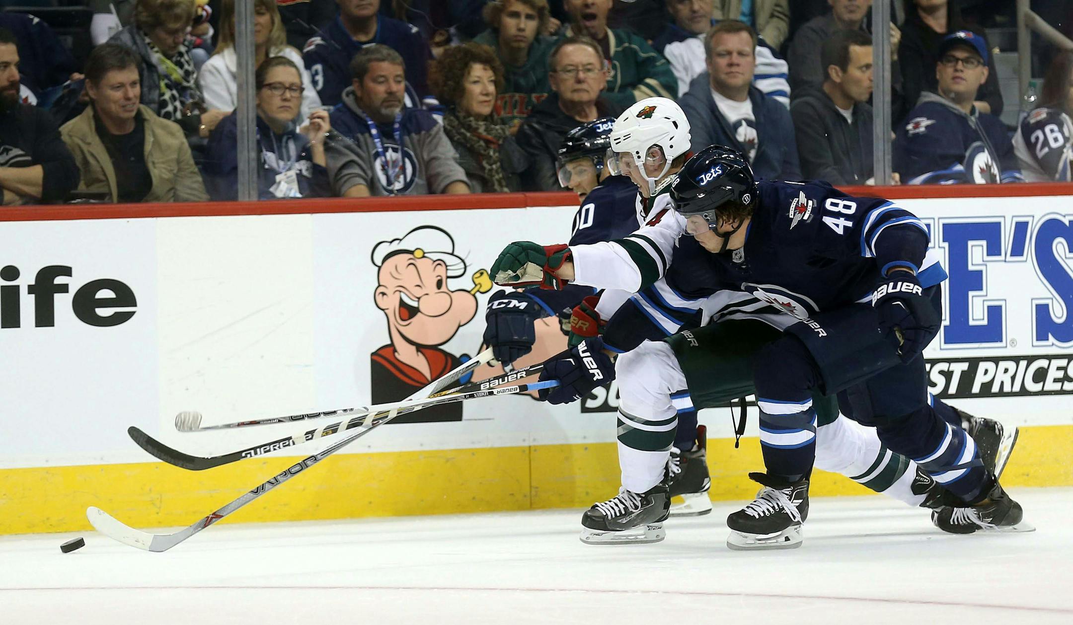 Winnipeg Jets' Joel Armia, left, and Brendan Lemieux, right, battle for the puck with Minnesota Wild's Mike Reilly during the second period of an NHL preseason hockey game Tuesday, Sept. 22, 2015, in Winnipeg, Manitoba. (Trevor Hagan/The Canadian Press via AP) MANDATORY CREDIT