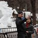 Ron Corbett and his wife Lany Corbett took a photo with ice sculptures art Rice Park. The current mild temperature at this years Winter Carnival are m