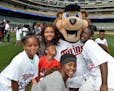 Twins Field Day participants cozy up with T.C. Bear on the outfield of Target Field.