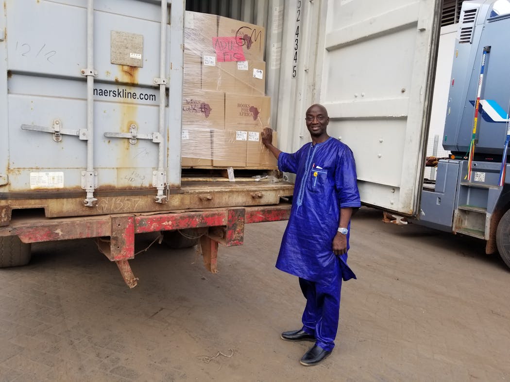 Lamin Dibba in the Gambia with a shipment of books.