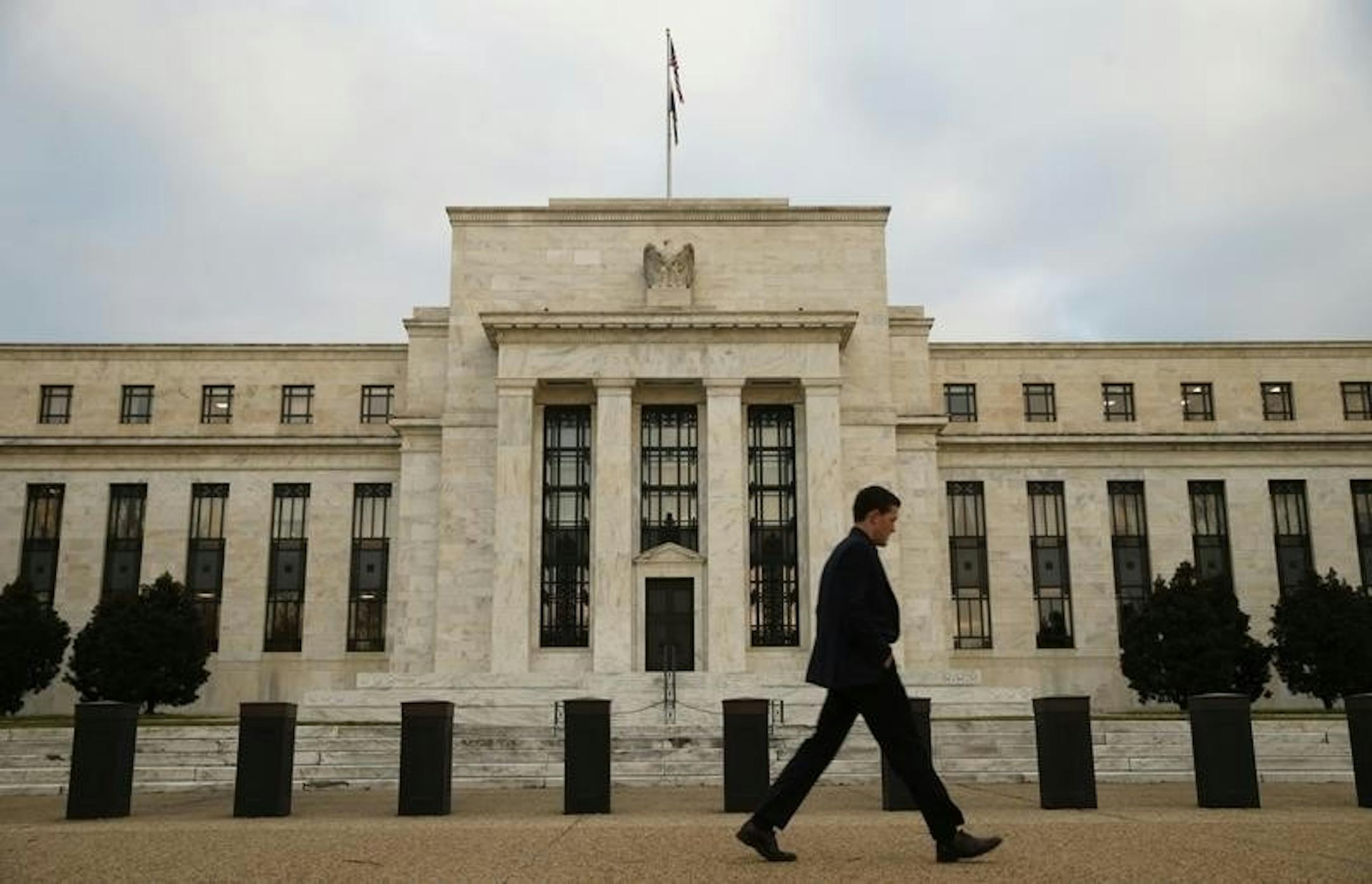 A man walks past the Federal Reserve in Washington.