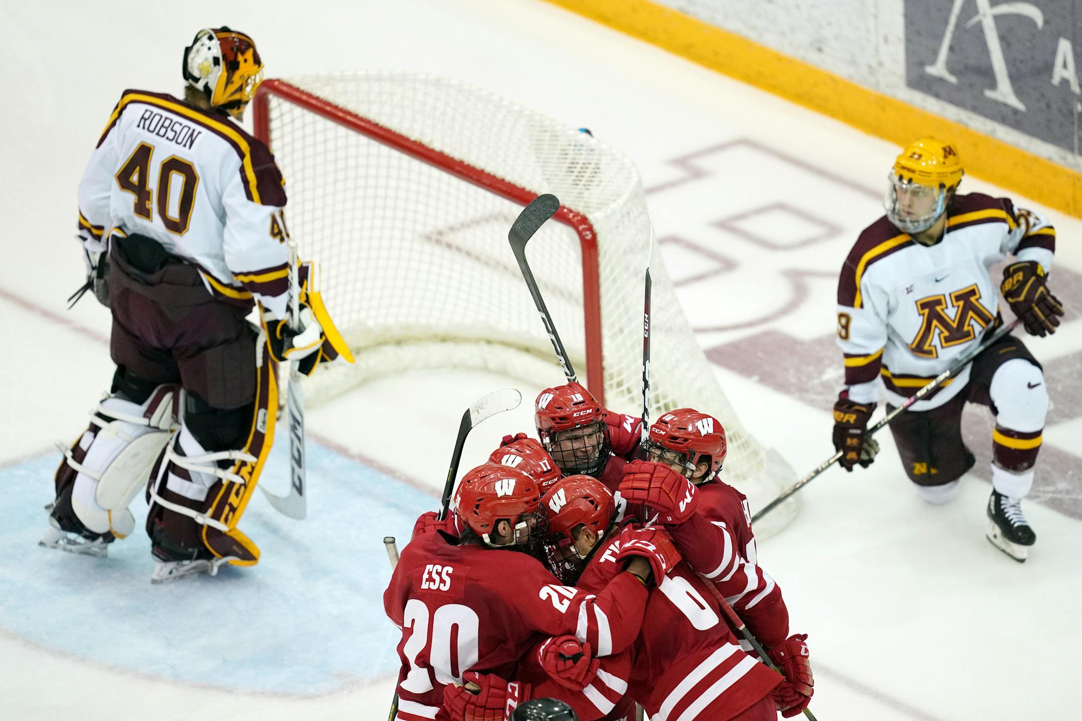 Wisconsin players celebrated with defenseman Peter Tischke (6) after he scored the game winning goal in the third period.