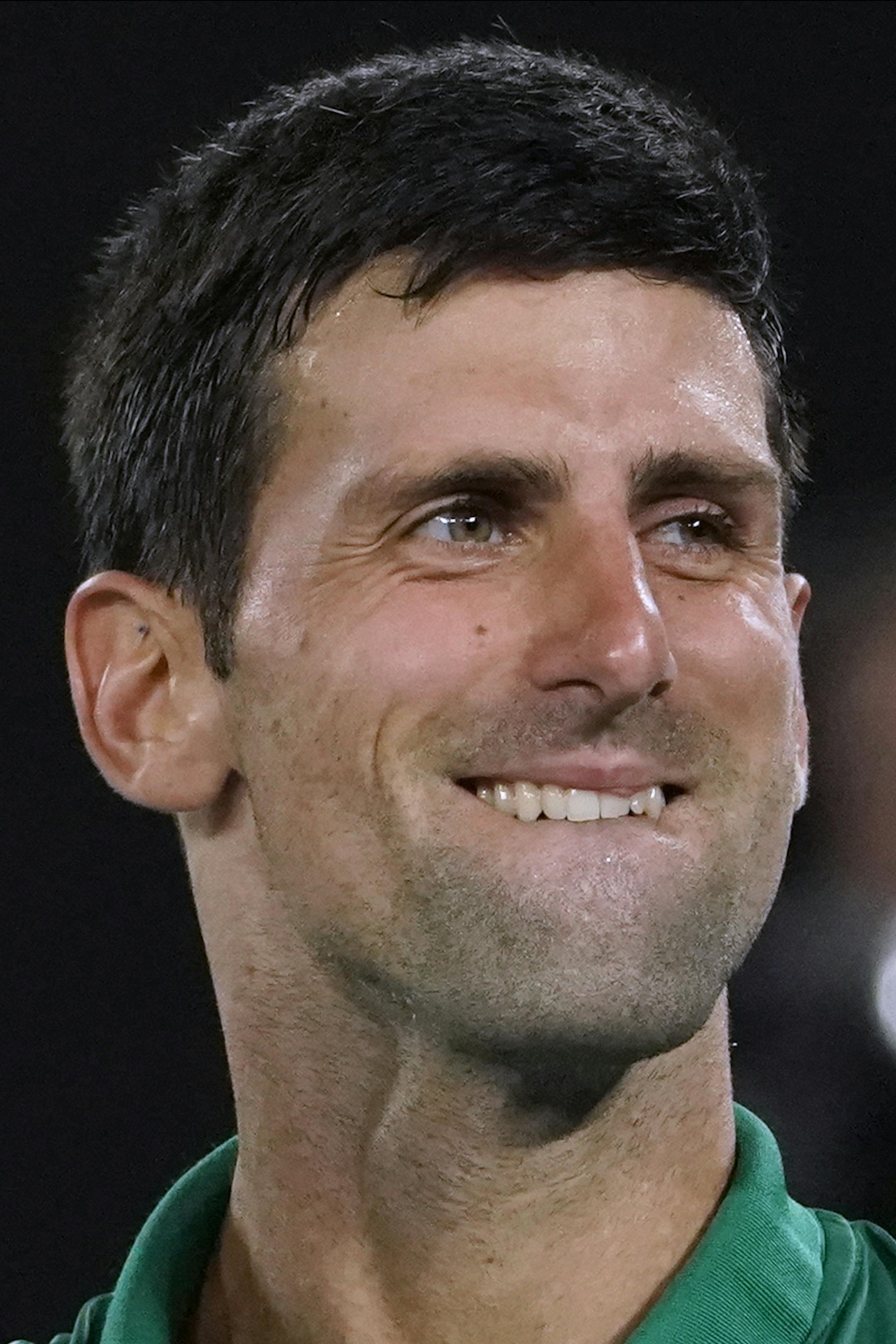 Serbia's Novak Djokovic celebrates after defeating Switzerland's Roger Federer in their semifinal match at the Australian Open tennis championship in Melbourne, Australia, Thursday, Jan. 30, 2020. (AP Photo/Lee Jin-man)
