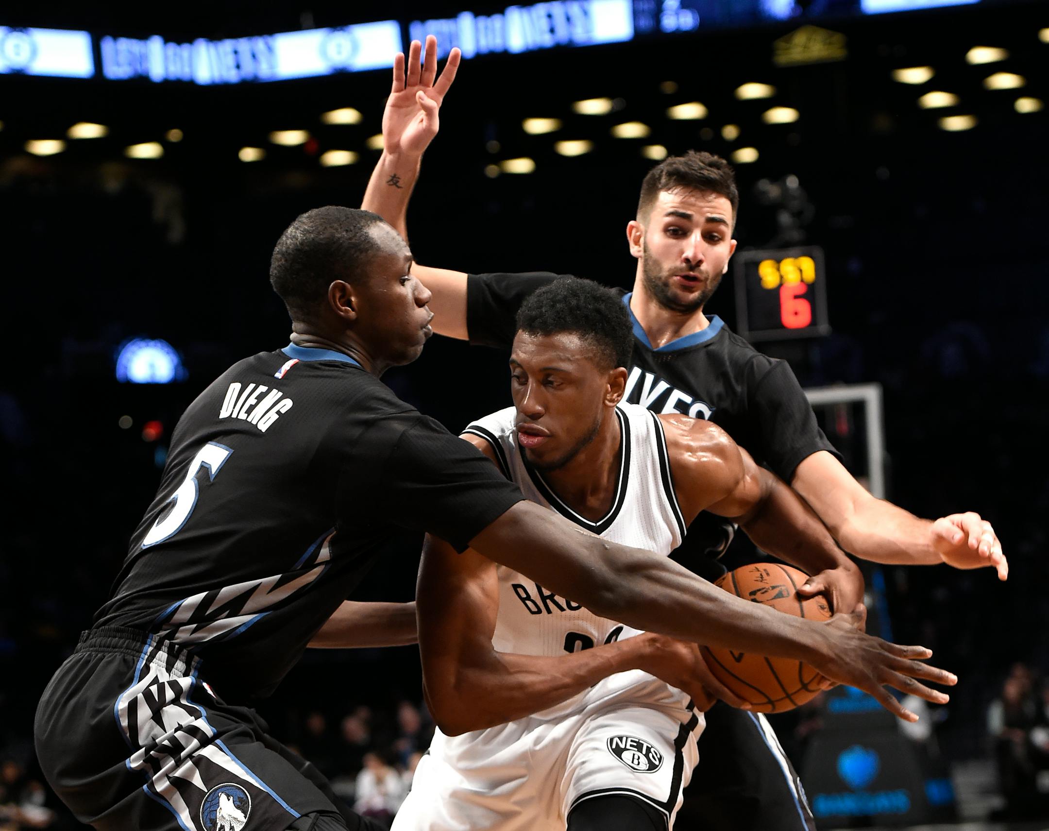Minnesota Timberwolves center Gorgui Dieng (5) and guard Ricky Rubio (9) surround Brooklyn Nets forward Thaddeus Young (30) during the second half of an NBA basketball game on Sunday, Dec. 20, 2015, in New York. The Timberwolves won 100-85. (AP Photo/Kathy Kmonicek)