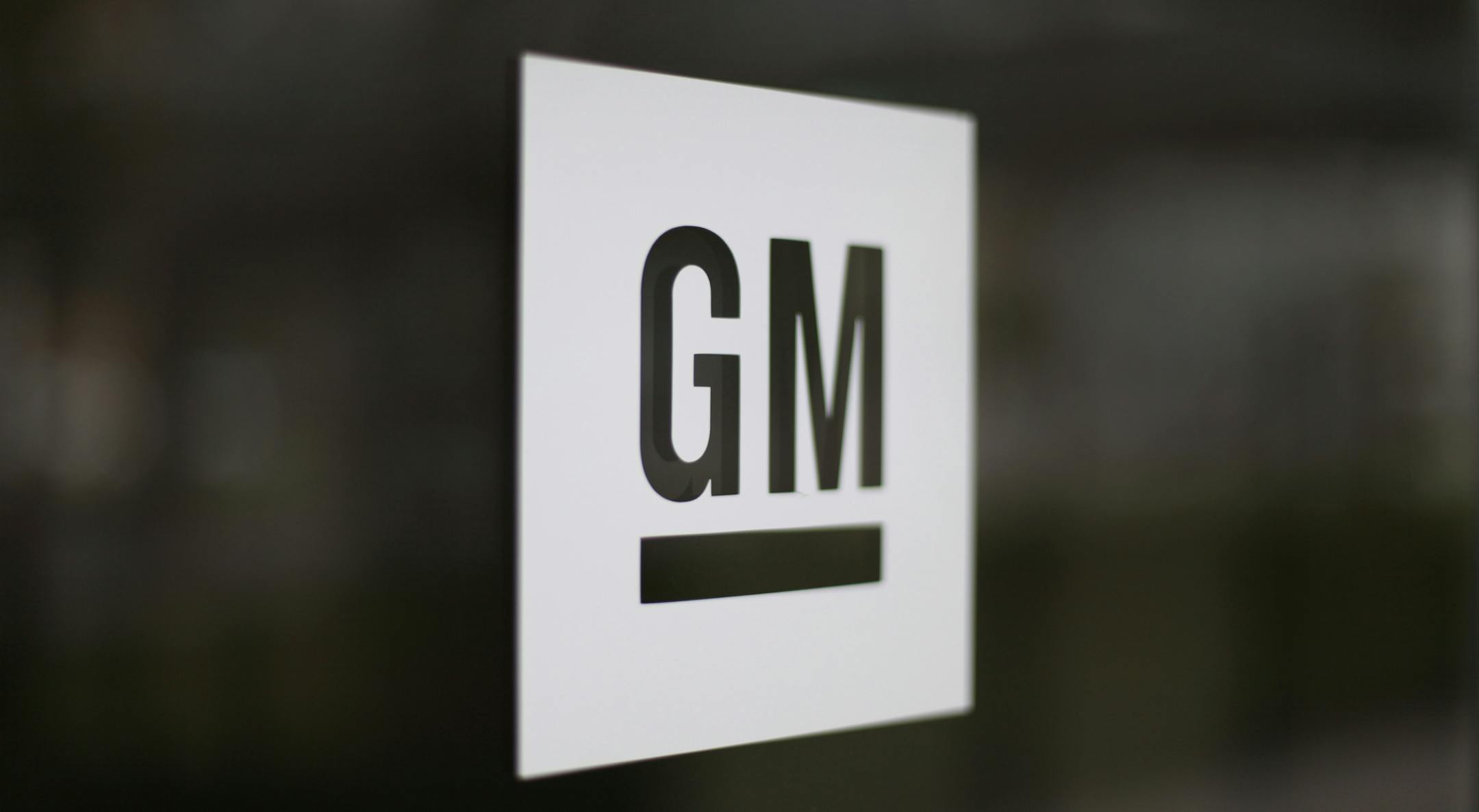 FILE - This Friday, May 16, 2014, file photo, shows the General Motors logo at the company's world headquarters in Detroit. In another tweet targeting GM, President-elect Donald Trump is threatening to slap a tax on the U.S. automaker for importing compact cars to the U.S. from Mexico. But GM makes the vast majority of compact Chevrolet Cruzes at a sprawling factory complex in Lordstown, Ohio, near Cleveland. (AP Photo/Paul Sancya, File)