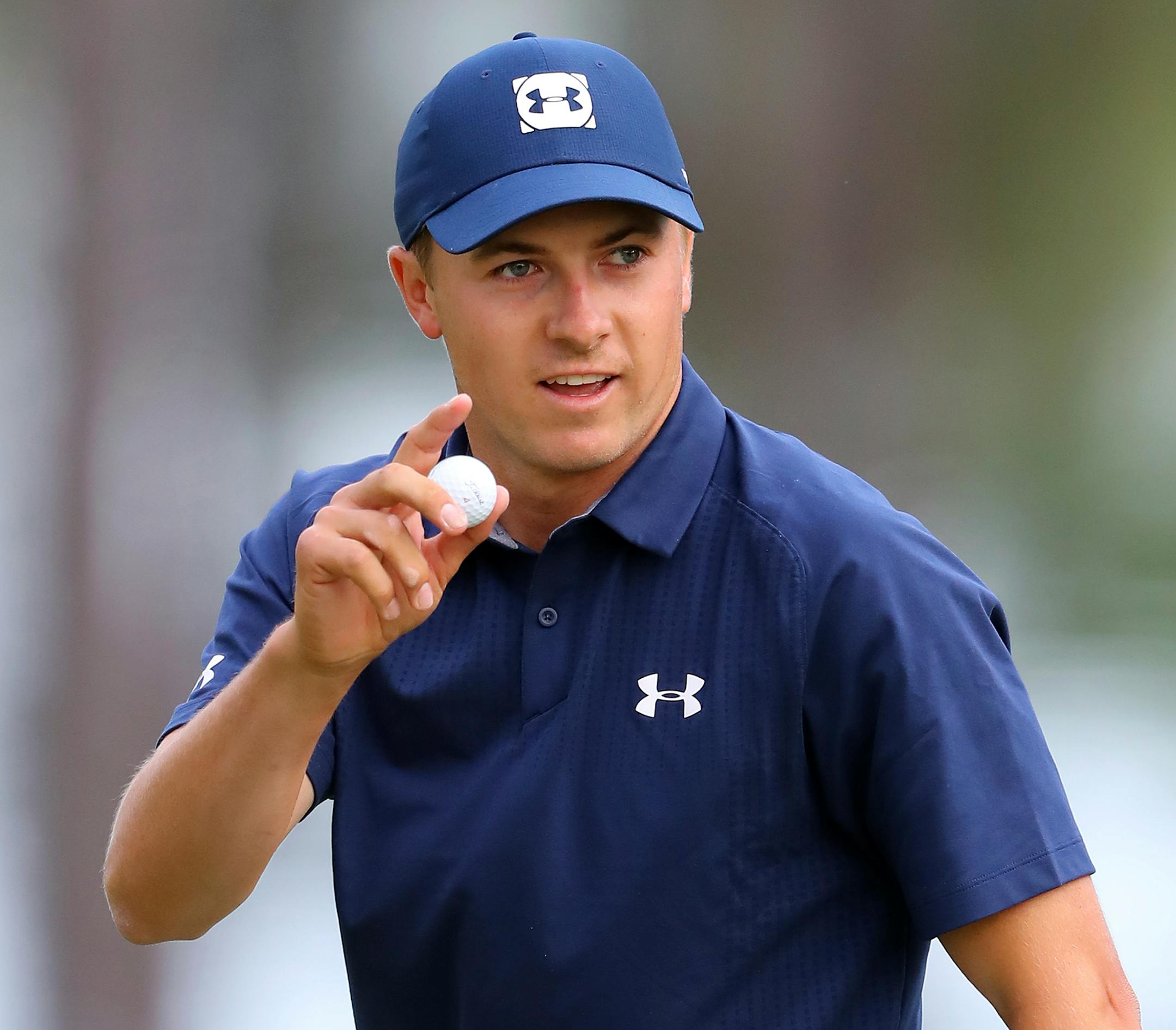 Jordan Spieth waves after making a birdie putt on the 16th hole during the first round at the Masters