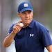 Jordan Spieth waves after making a birdie putt on the 16th hole during the first round at the Masters
