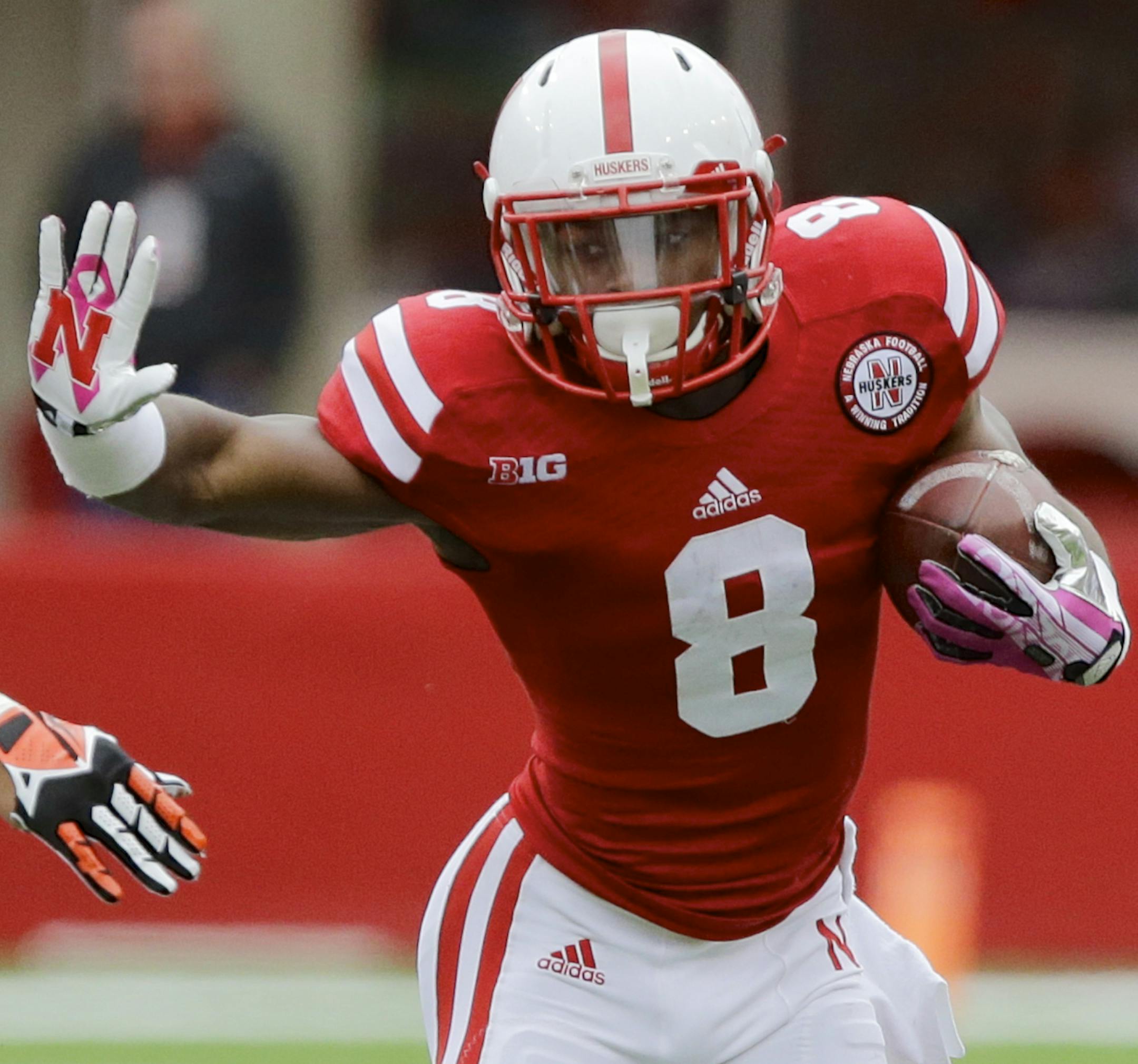 Nebraska running back Ameer Abdullah (8) runs past Illinois linebacker T.J. Neal (52) in the second half of an NCAA college football game in Lincoln, Neb., Saturday, Oct. 5, 2013. Abdullah ran for a career-high 225 yards and two touchdowns in Nebraska's 39-19 win. (AP Photo/Nati Harnik) ORG XMIT: NENH110