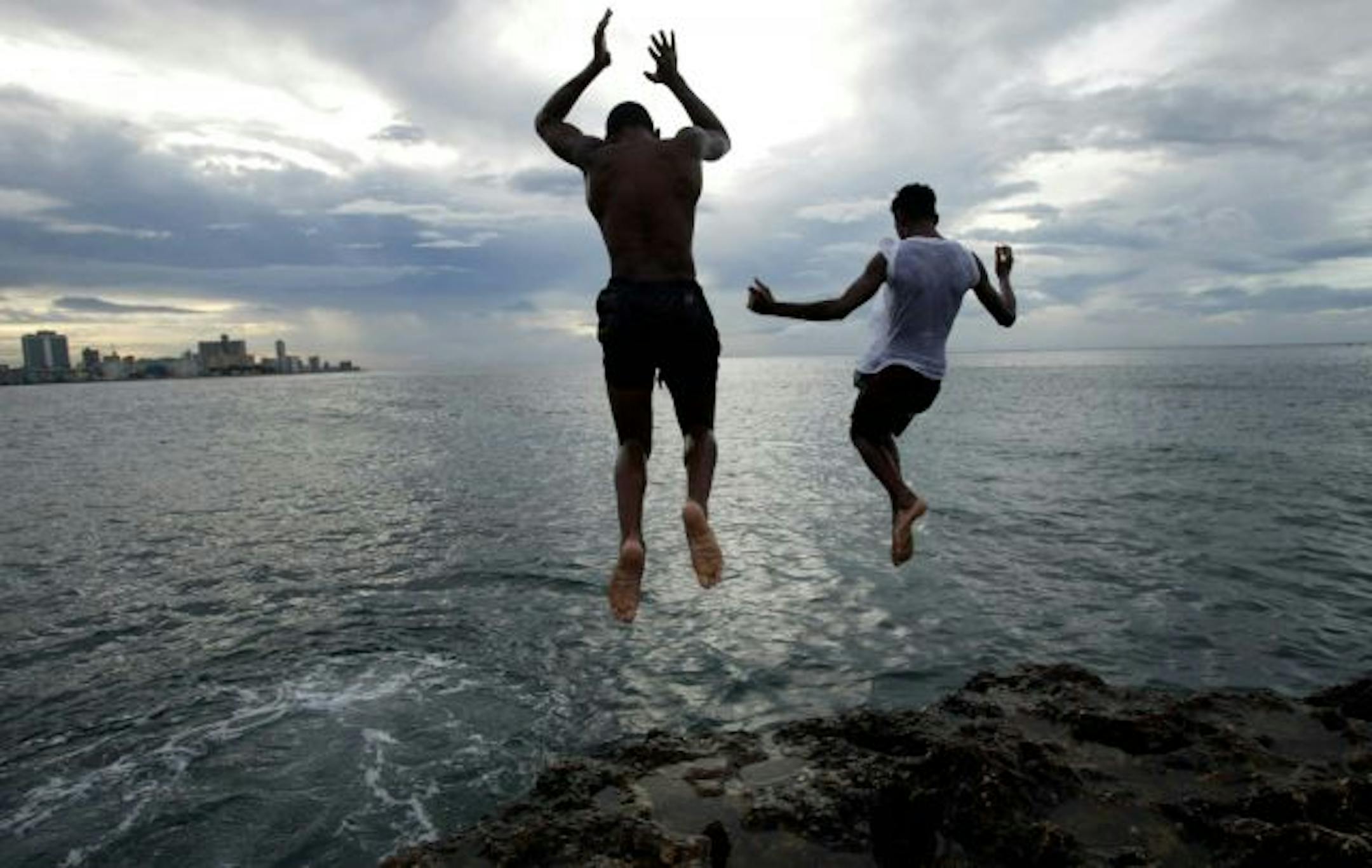 Luis Enrique, 15, and Nosley Jesus, 14 jump off the corral on the edge of a sea wall that protects Havana. The two frequently use this location to practice their dives.